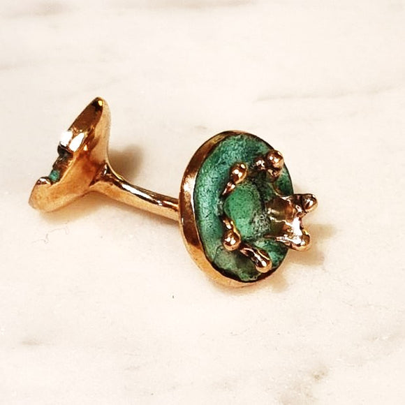 Round cufflink in the form of a water splash in bronze with blue green patina